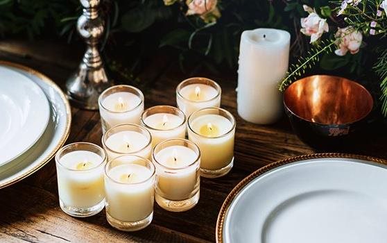 White candles on a table with dishes