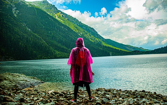 Woman with a pink Waterproof jacket on in front of the lake 
